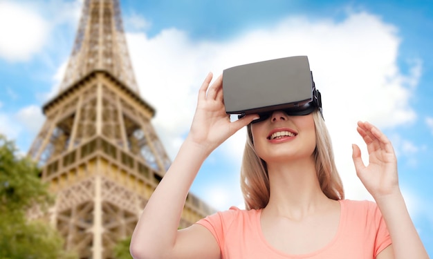 technologie, virtual reality, entertainment, reizen en mensenconcept - gelukkige jonge vrouw met virtual reality-headset of 3D-bril over de achtergrond van de Eiffeltoren