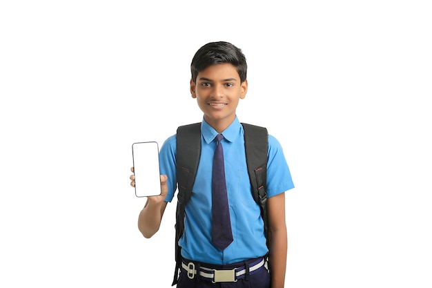 Technologieconcept Schattige Indiase kleine schooljongen met smartphone