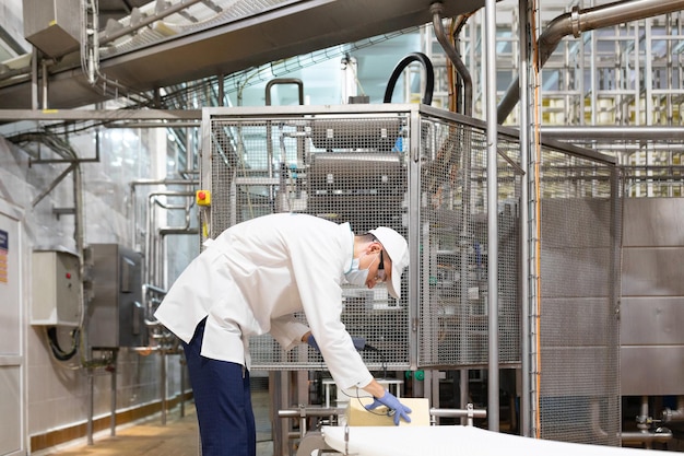 Technologist make set up of the production line while standing near digital screen at the department of dairy factory