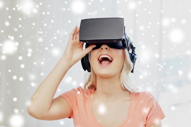 Foto tecnologia realtà aumentata cyberspace intrattenimento e persone concetto felice meravigliato giovane donna in cuffie virtuali o occhiali 3d e cuffie a casa
