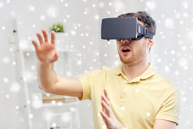 technology, augmented reality, gaming, entertainment and people concept - amazed young man with virtual headset or 3d glasses playing game over snow