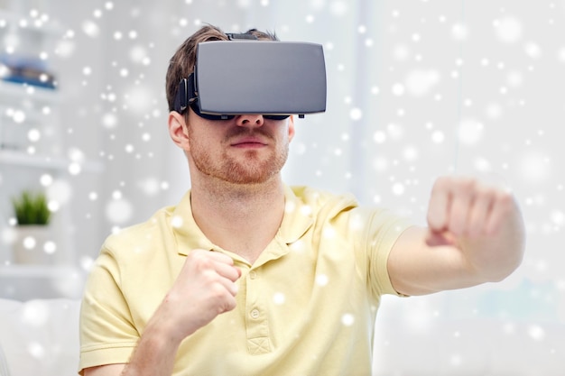 technology, augmented reality, gaming, entertainment and people concept - young man with virtual headset or 3d glasses playing combat game and fighting over snow