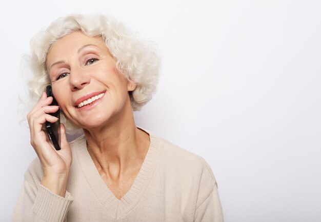 technology communication age and people concept happy senior woman with smartphone over white background