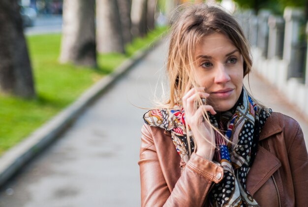 Photo technology, communication, lifestyle and people concept - smiling young woman or teenage girl calling on smartphone on city street