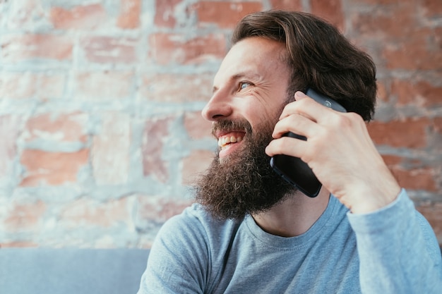 テクノロジーコミュニケーションと最新のガジェット。携帯電話で話している男。