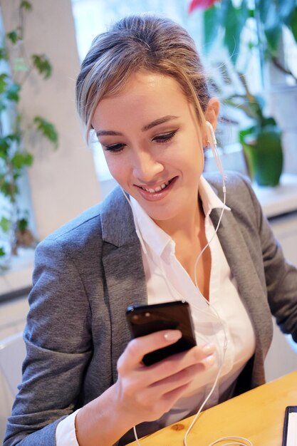 Technology communication and people concept happy young woman calling on smartphone at office