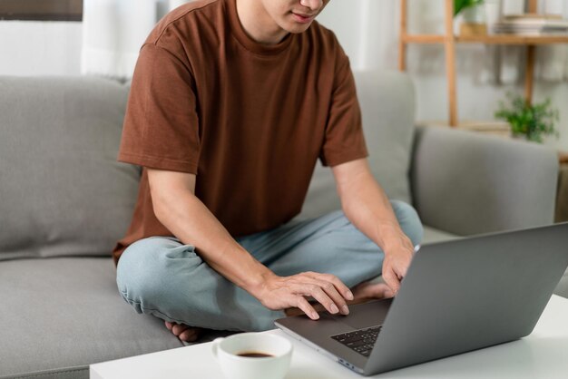 Concetto di tecnologia l'uomo in maglietta marrone che si concentra sulla digitazione di qualcosa