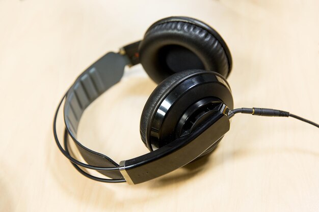 Photo technology, electronics and audio equipment concept - close up of headphones at recording studio or radio station