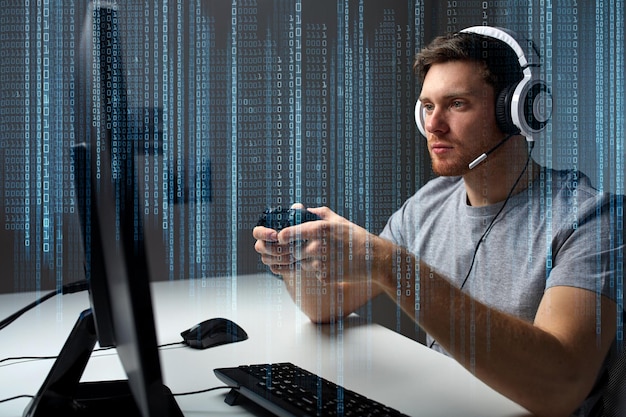 technology, gaming, entertainment, let&amp;#39;s play and people concept - young man in headset with controller gamepad playing computer game at home and streaming playthrough or walkthrough video