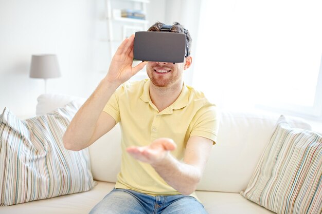 technology, gaming, entertainment and people concept - happy young man with virtual reality headset or 3d glasses playing video game