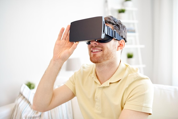 technology, gaming, entertainment and people concept - happy young man with virtual reality headset or 3d glasses playing video game