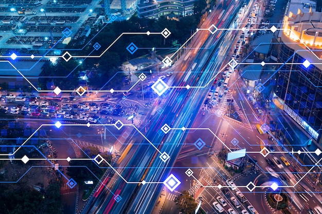 Technology hologram on aerial view of road busy urban traffic\
highway at night junction network of transportation infrastructure\
the concept of developing hightech science in logistics