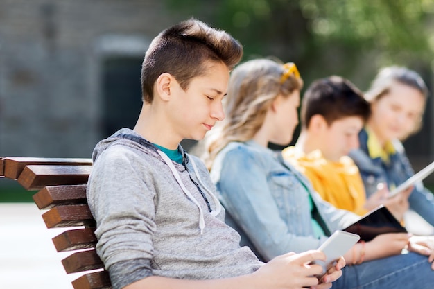 technology, internet and people concept - happy teenage boy with tablet pc computer outdoors