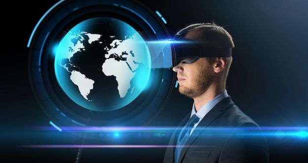 テクノロジー、人、サイバースペース、マスメディア、拡張現実のコンセプト – 黒い背景に仮想ヘッドセットまたは3Dメガネと地球ホログラムを持つ青年実業家