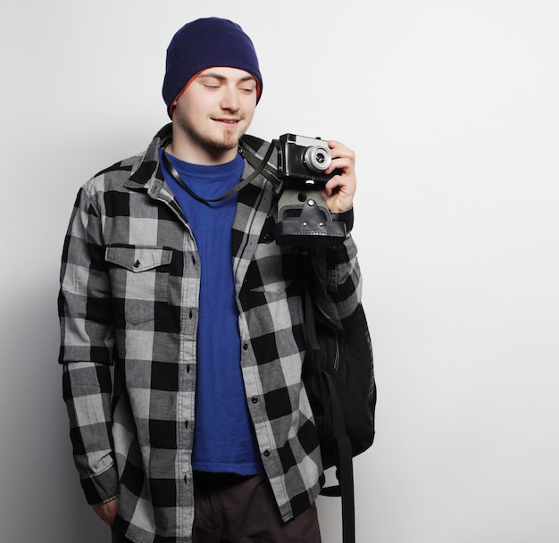 Tecnologia, persone e concetto di stile di vita: giovane fotografo su sfondo bianco