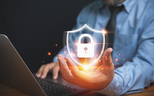 個人の個人データを保護するためのセキュリティ技術 テクノロジー ビジネスとイノベーションのコンセプト プライバシーの侵害を守るために盾を手にロックを持つビジネスマン