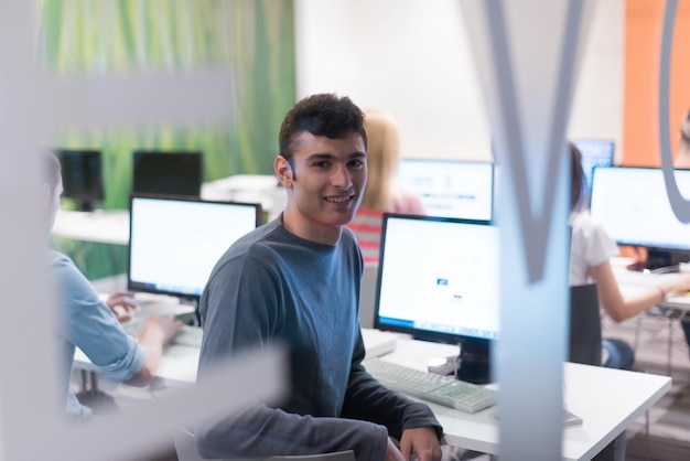 Foto gruppo di studenti di tecnologia nell'aula scolastica di laboratorio di informatica su cui lavorano