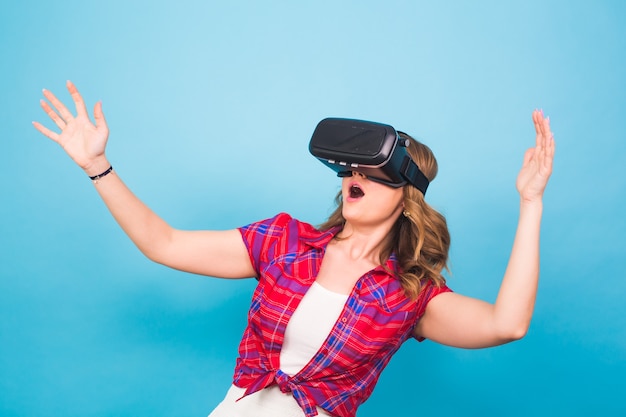 Technology, virtual reality, entertainment and people concept - happy young woman with virtual reality headset.