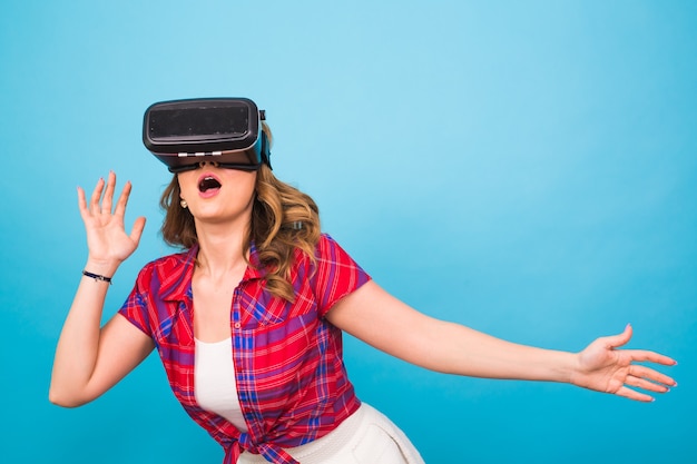 Technology, virtual reality, entertainment and people concept - happy young woman with virtual reality headset.