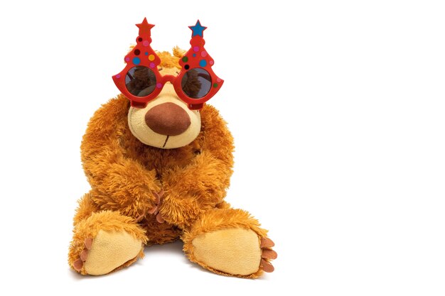 Photo teddy bear in festive glasses on a white background.