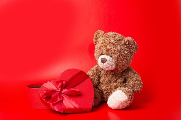 Teddy bear heart shaped box on red background valentine's day