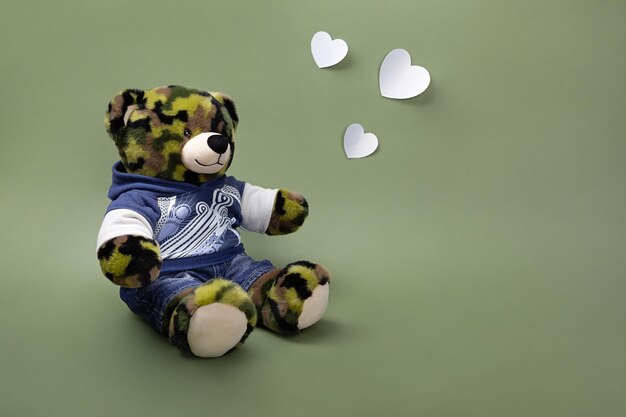 Teddy bear and hearts on green background