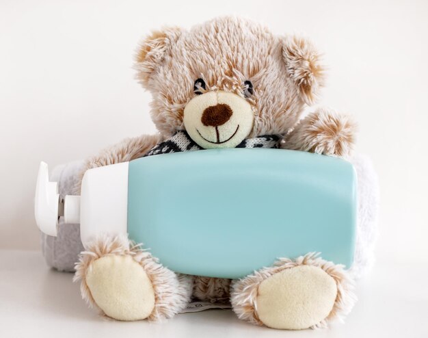 A teddy bear holding a blue soap bottle that says " milk ".