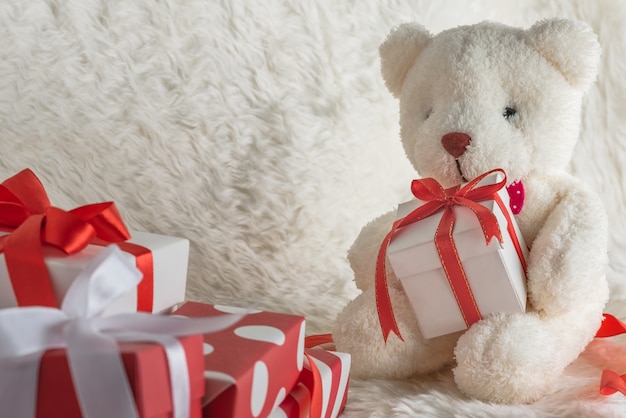 Photo teddy bear holding a gift tied with red ribbon
