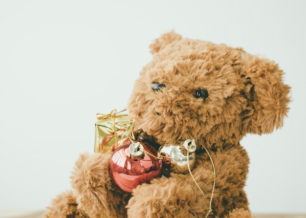 Teddy bear hug christmas bubble gift on wood table.