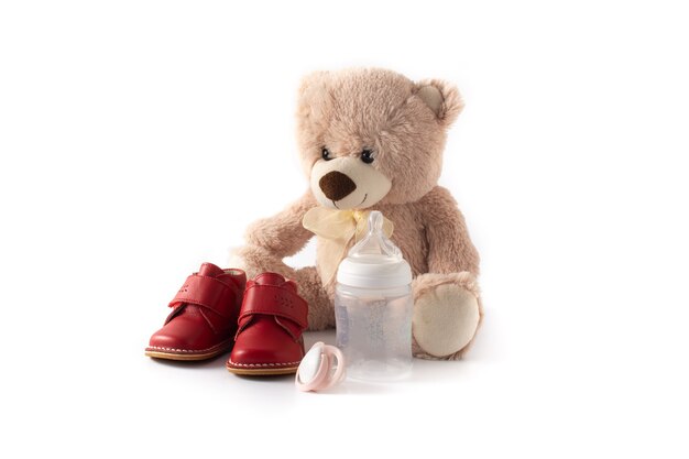 Teddy bear pacifierfeeding bottle and shoes isolated