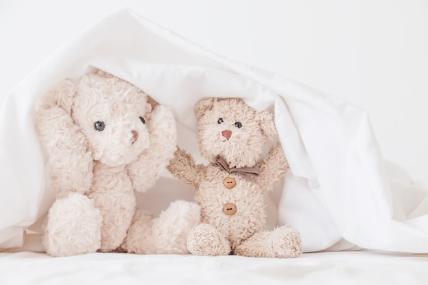 Teddy bear playful in white blanket