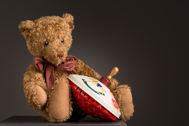 Teddy bear sitting with a spinning top