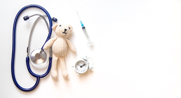 Teddy bear stethoscope and syringe isolate on a white background. Selective focus.