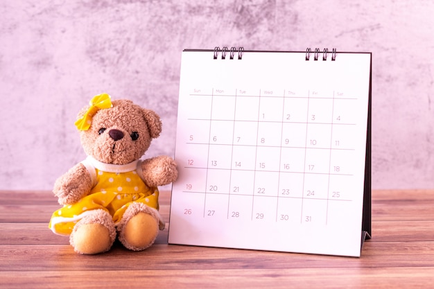 Teddy bear with calendar on table