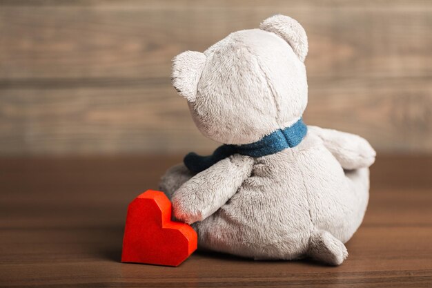 Teddy bear with heart on light background