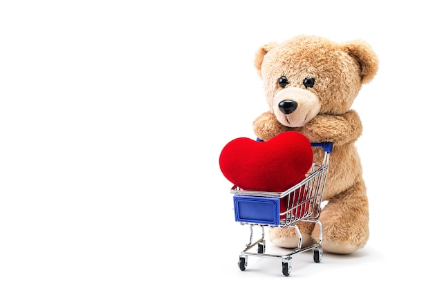Teddy bear with heart shaped pillow in a cart