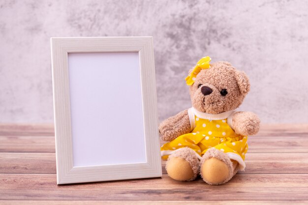 Teddy bear with picture frame on table