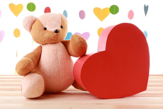 Teddy Bear with red heart on festive background