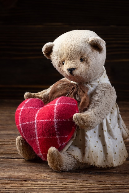 Teddy bear with a red heart on a wooden table