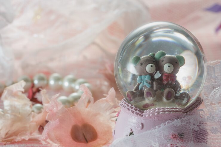 Photo teddy bears in snow globe on pink fabric with pearl necklace