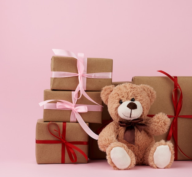 Teddybeer en geschenken verpakt in bruin eco kraftpapier en vastgebonden met een lint