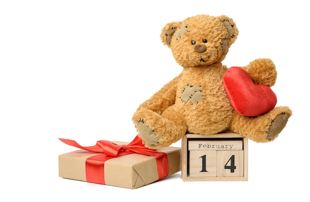 Teddybeer en houten kalender met datum 14 februari en doos met een geschenk op wit, Valentijnsdag