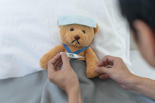 Teddybeer en verband met thermometer ziek en verwondingsconcept