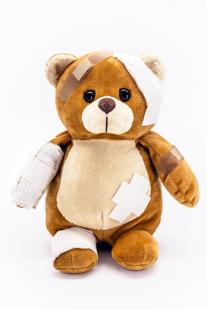 Teddybeer gekneusd pluche speelgoed met verbanden jeugd bedreigd conceptueel beeld huiselijk geweld of kindermishandeling