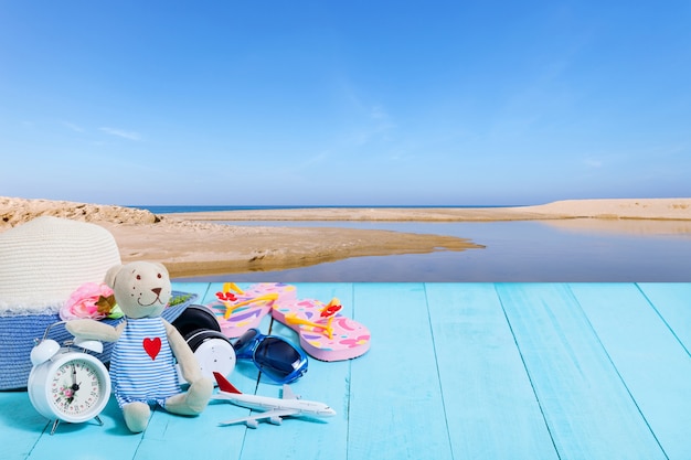 Foto teddybeer met witte wekker, strandaccessoire, hoed, zonnebril, schoenen