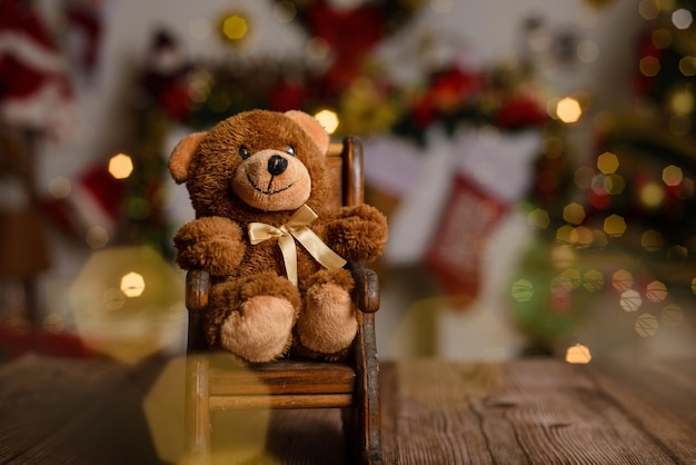 Teddybeer op houten tafel met onscherpe kerstachtergrond