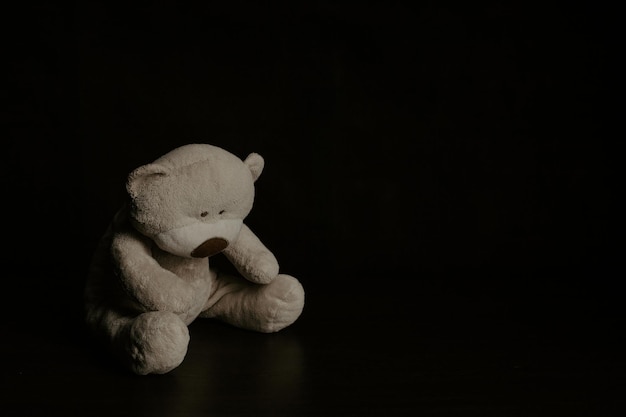 Teddybeer zit in het donker Kindermishandeling en strafconcept Eenzaam concept