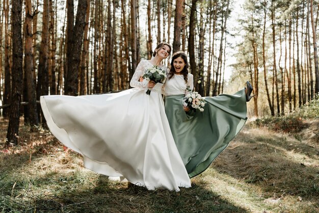 Tedere bruid met lachende bruidsmeisjes gekleed in lange elegante jurken, bruidsmeisjes met gelukkige bruid op trouwdag. bruidsboeketten worden gehouden door vriendinnen, trouwdag,