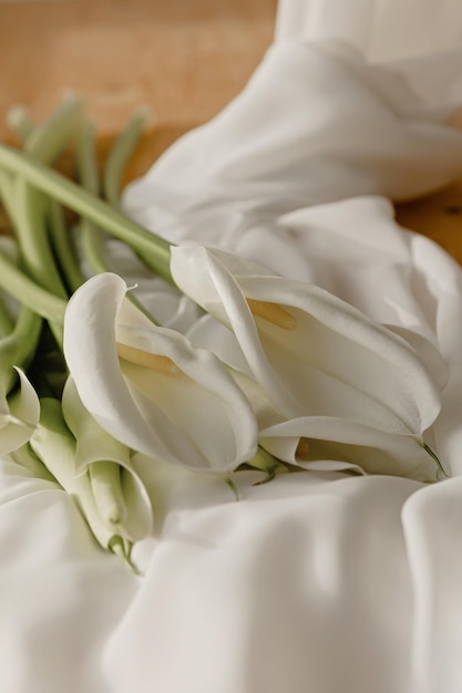 Tedere callae op witte stof Trouwbloemen
