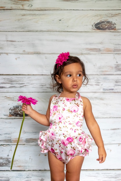 Foto tedere glimlachende peuter, met een bloem in haar hand